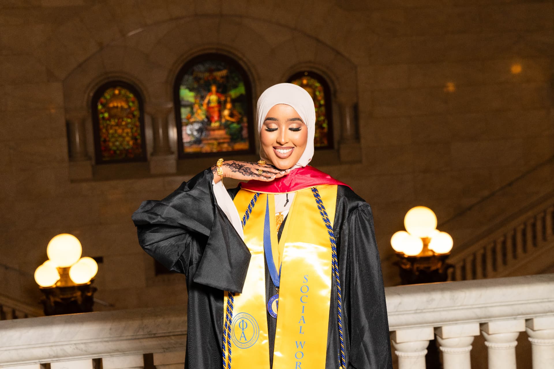 Graduate in black gown and gold honor stole at the Minnesota State Capitol