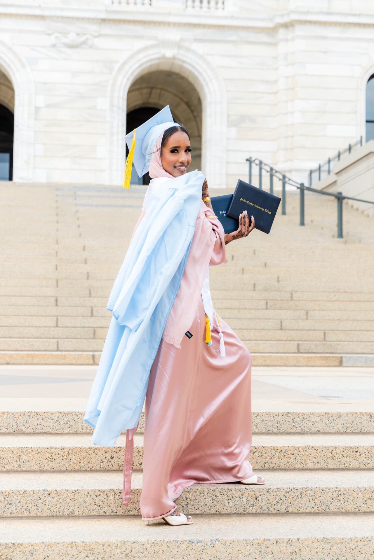 Graduate on the Capitol steps holding her diploma